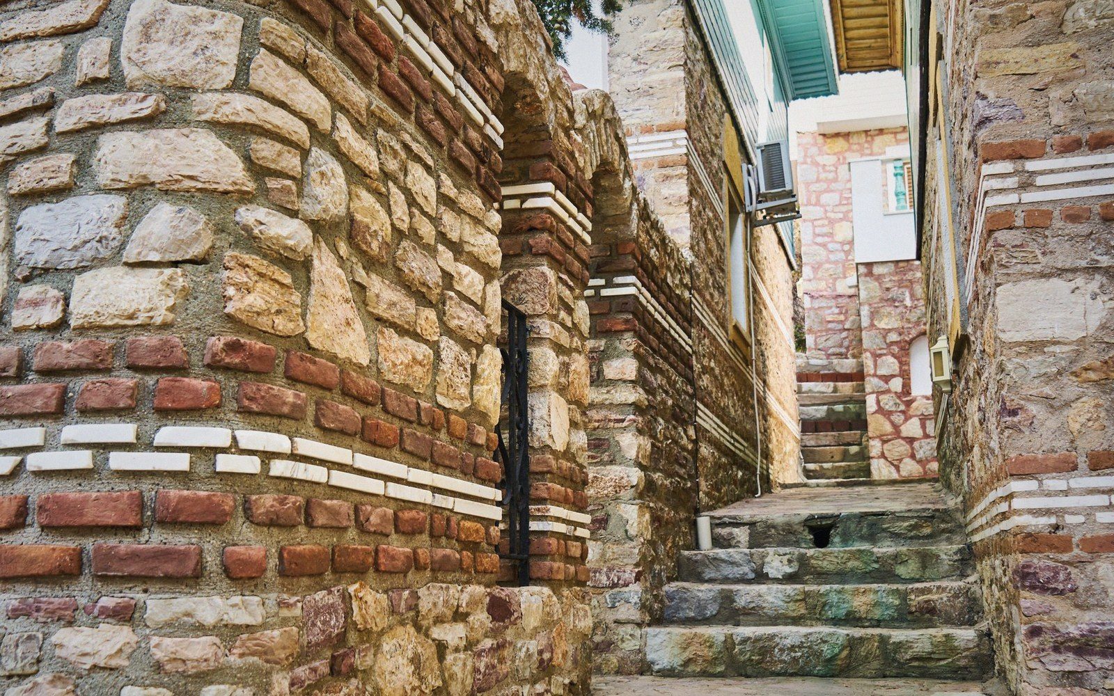 A public building entrance with broad stone steps front-and-centre; a narrow ramp runs off to the far left behind a wall